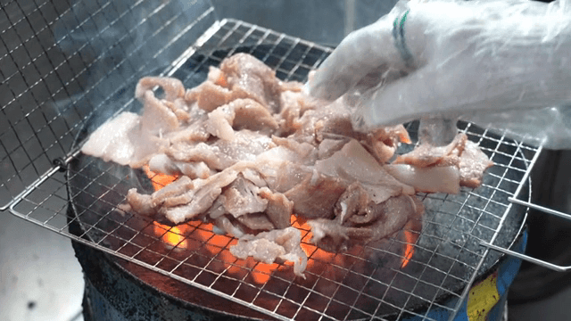 숯불 위에 양념된 고기 굽기