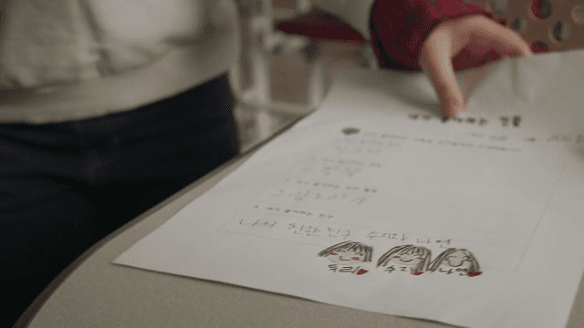 교실에 걸어 들어와 책상에 종이를 올려놓는 아이