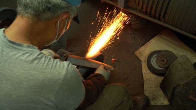 Worker sharpening a knife in a workshop