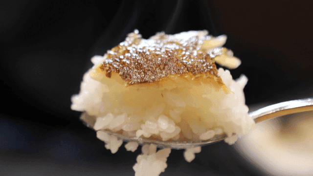Spoonful of rice topped with crispy grilled fish