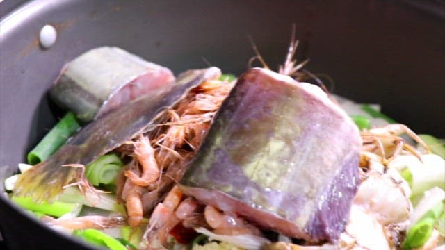 주방에서 싱싱한 생선과 채소로 조리하는 매운탕