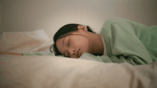 Young woman lying face down on bed and sleeping