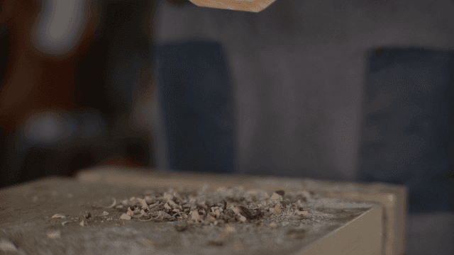 반원 모양 나무 조각을 들고 있는 목공예 장인