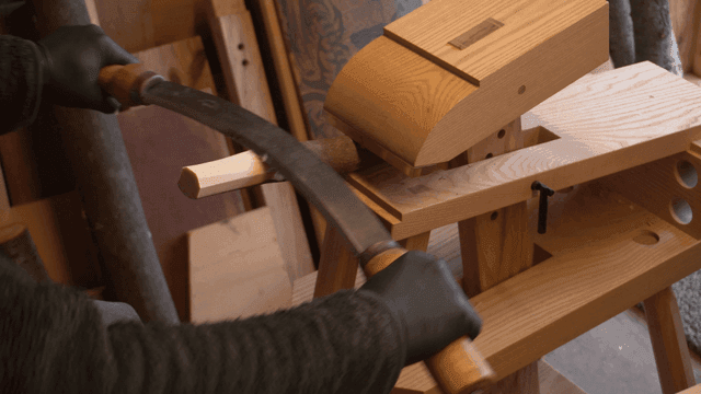 작업장에서 나무 막대를 드로우나이프로 담드는 공예가