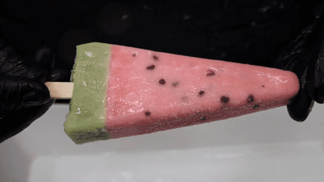 Watermelon-shaped popsicle being held
