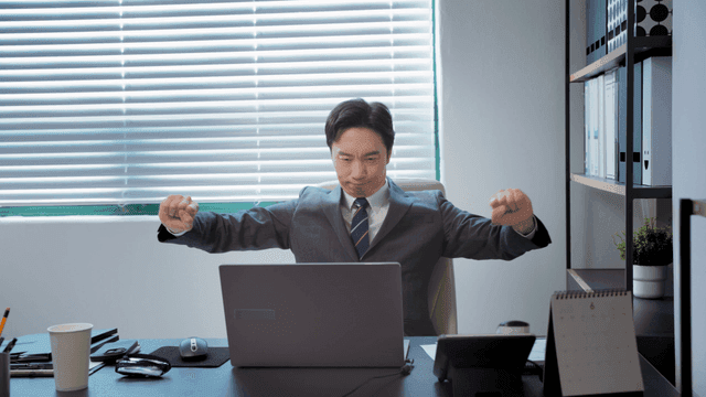 사무실에서 책상에 앉아 일하는 사업가