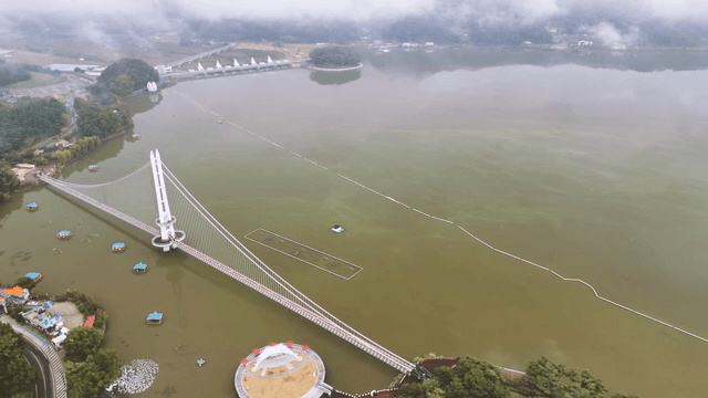 안개 낀 하늘과 잔잔한 호수 위의 다리
