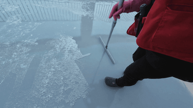 땅바닥에서 눈을 청소하는 사람