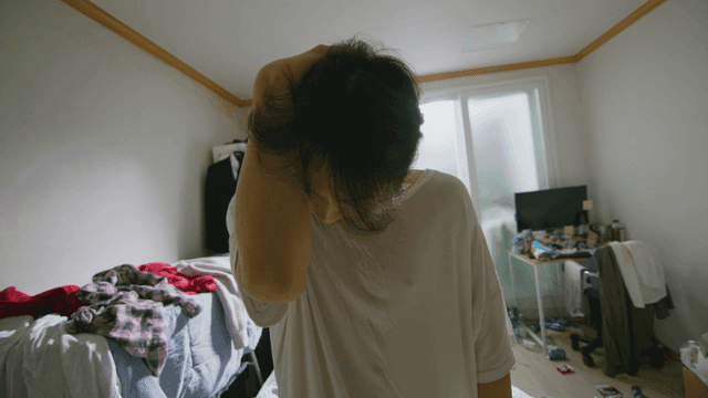 어수선한 방에 있는 젊은 남성