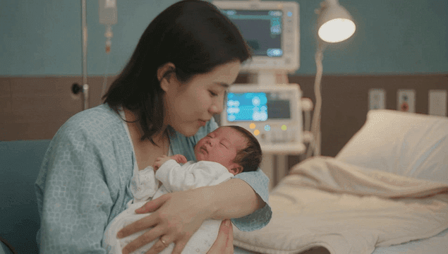 Mother holding a newborn in a hospital room