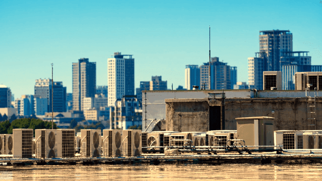 Building rooftop with air conditioner outdoor units visible from high-rise buildings