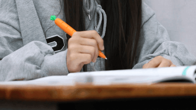 Student writing notes in a classroom