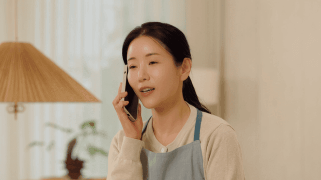 Woman talking on phone while folding laundry