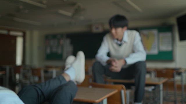 Students having a conversation in a classroom with poor pose