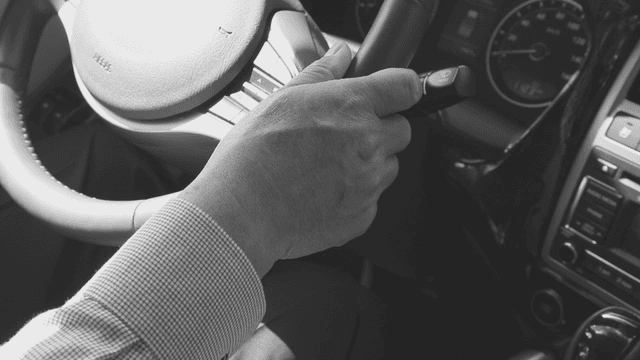 Hands gripping a steering wheel in a car