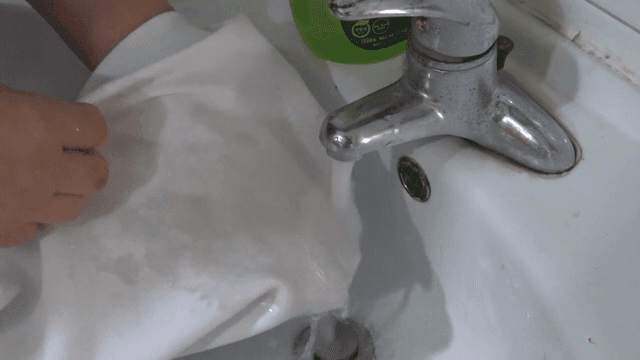세면대에서 흰 천을 손으로 세탁