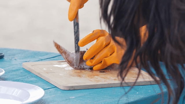 도마 위에서 생선을 손질하는 사람