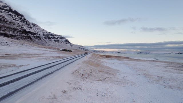 Snowy road by the mountains and sea