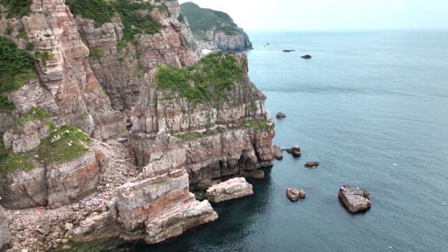 흐린 날 절벽에 백령도 간판이 있는 해안가