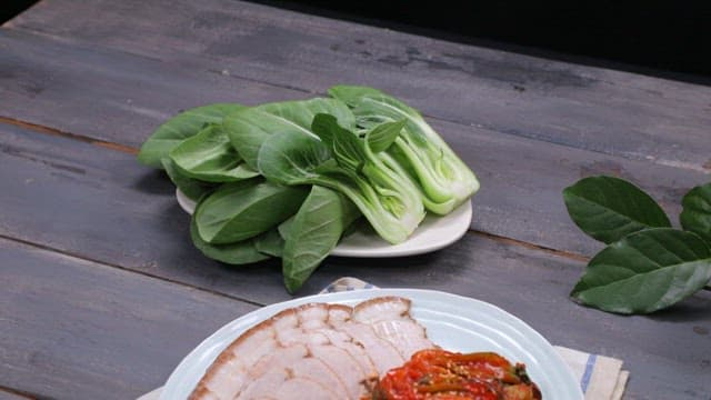 Plate of Korean boiled pork with bok choy kimchi