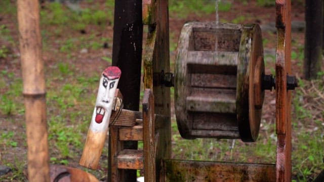 얼굴이 새겨진 야외 나무 물레방아