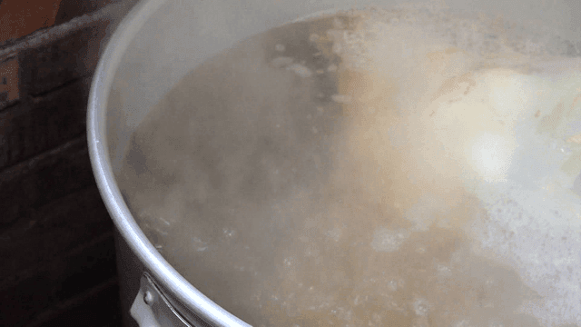 Large pot of clear hot broth boiling