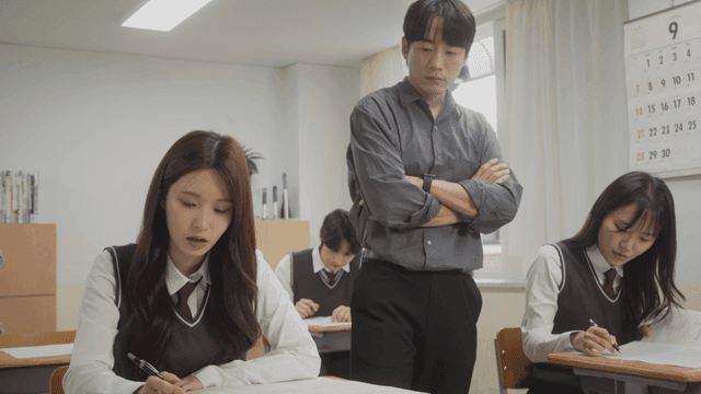 교실에서 시험을 보는 학생들을 감독하는 선생님