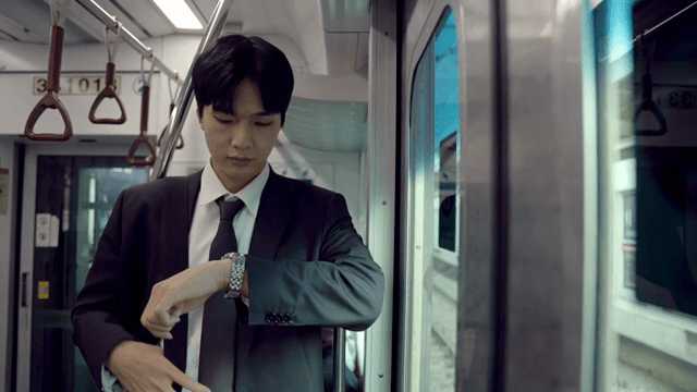 Office worker looking at watch on subway