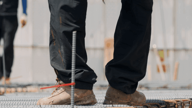 Construction workers tying rebar on site