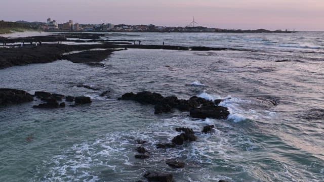 파도가 치는 해질녘 바위 해안