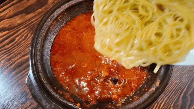 Noodles poured into spicy stew