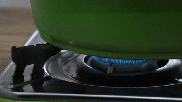 가스레인지 위에서 가열되는 녹색 냄비