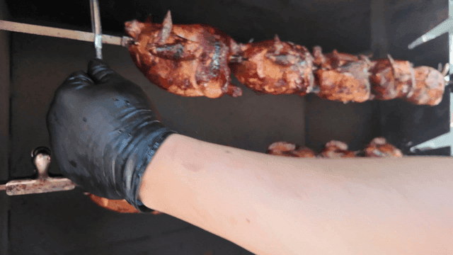 Hand taking out rotisserie chicken