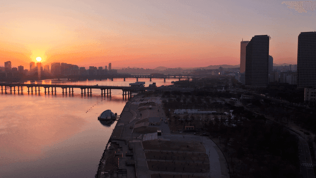 Sunset over a river with city skyline