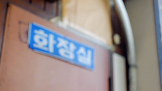 나무문에 붙은 화장실 표지판