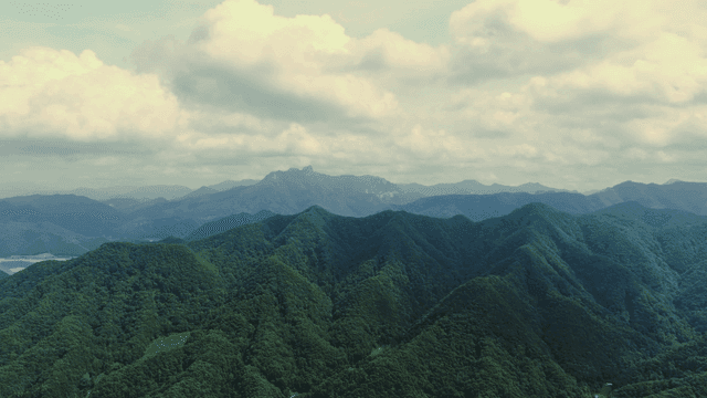 구름 낀 하늘 아래 푸른 산