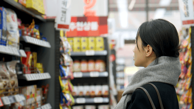 Young woman browsing snacks at supermarket