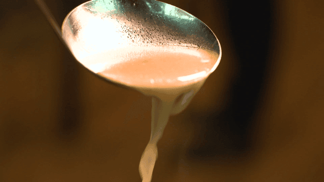 Soup being poured from a ladle