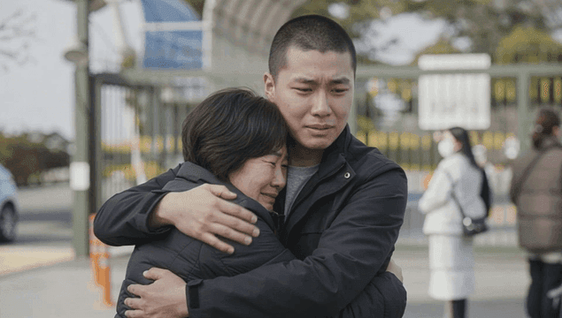 Touching embrace between mother and son as they enlist.