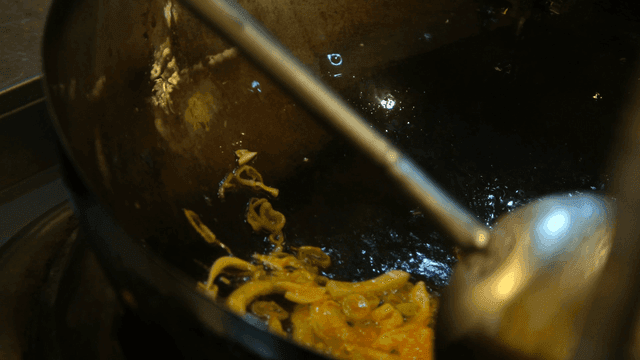Stir-fry onions in hot wok
