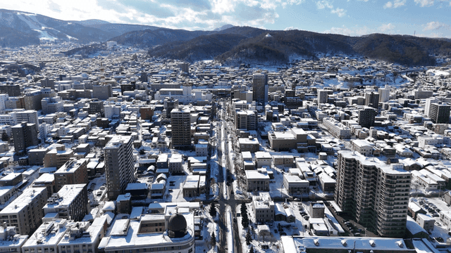 Snow-covered cityscape with distant mountains