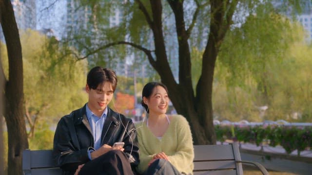 Couple checking their smartphones on a park bench