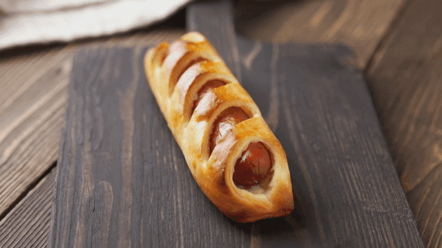 Freshly baked sausage bread on a wooden board