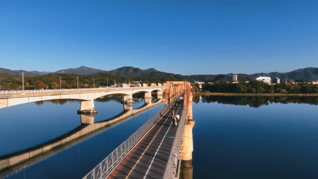 호수 위의 다리에서 자전거를 타는 사람들