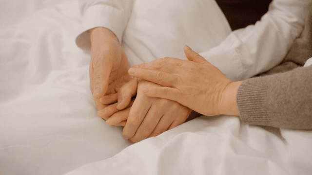 침대에서 손을 잡고 있는 두 사람