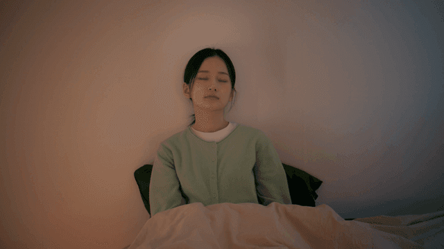 Woman sleeping with her bed leaning against wall