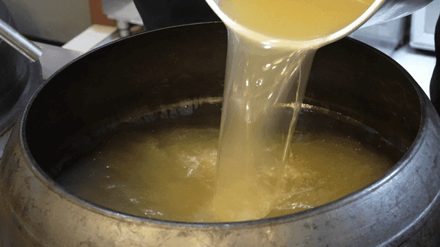 Broth poured into large cauldron