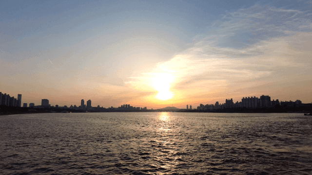 Sunset over a river with city skyline
