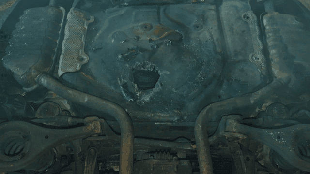 Overturned smoking underbody of damaged car on road