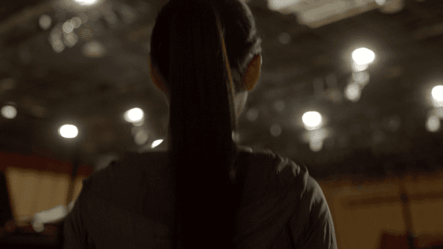 Back view of woman walking into bright gym